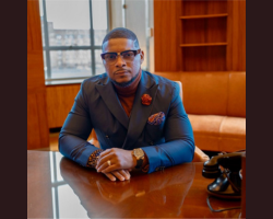 John Scott sitting at table looking at camera